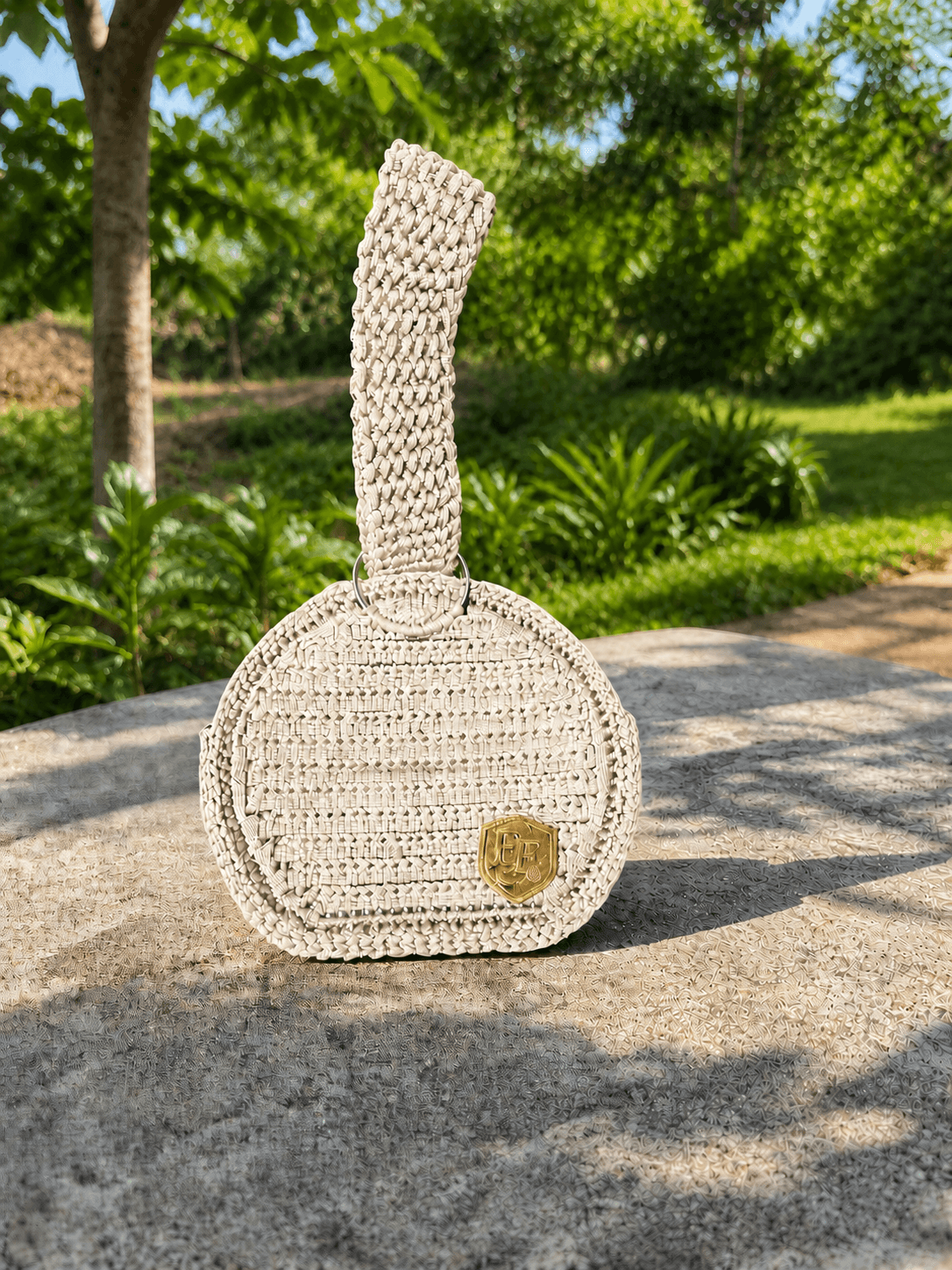 Nova handcrafted crochet bag in ivory outdoor setting.